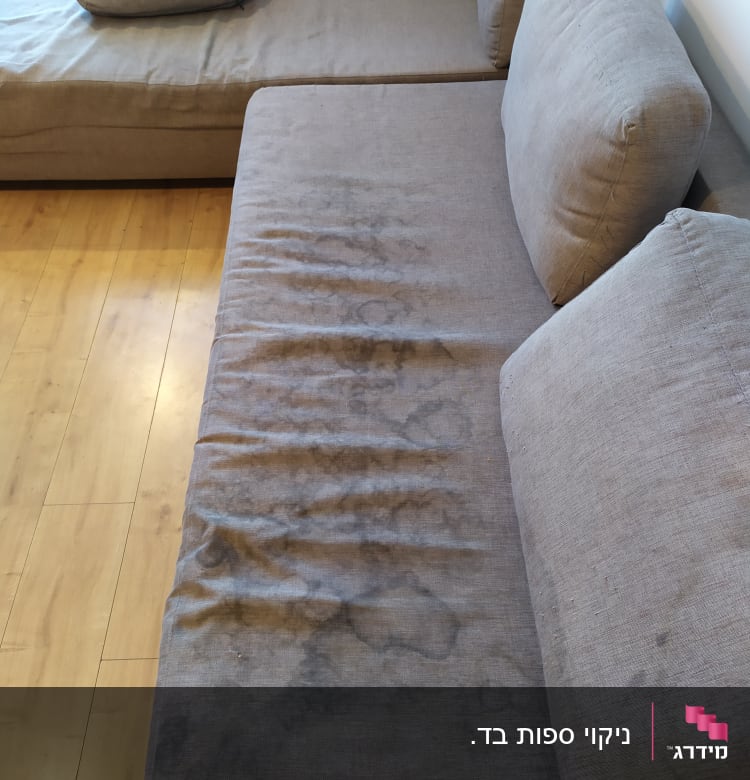 ספה אפורה עם כתמים על הריפוד